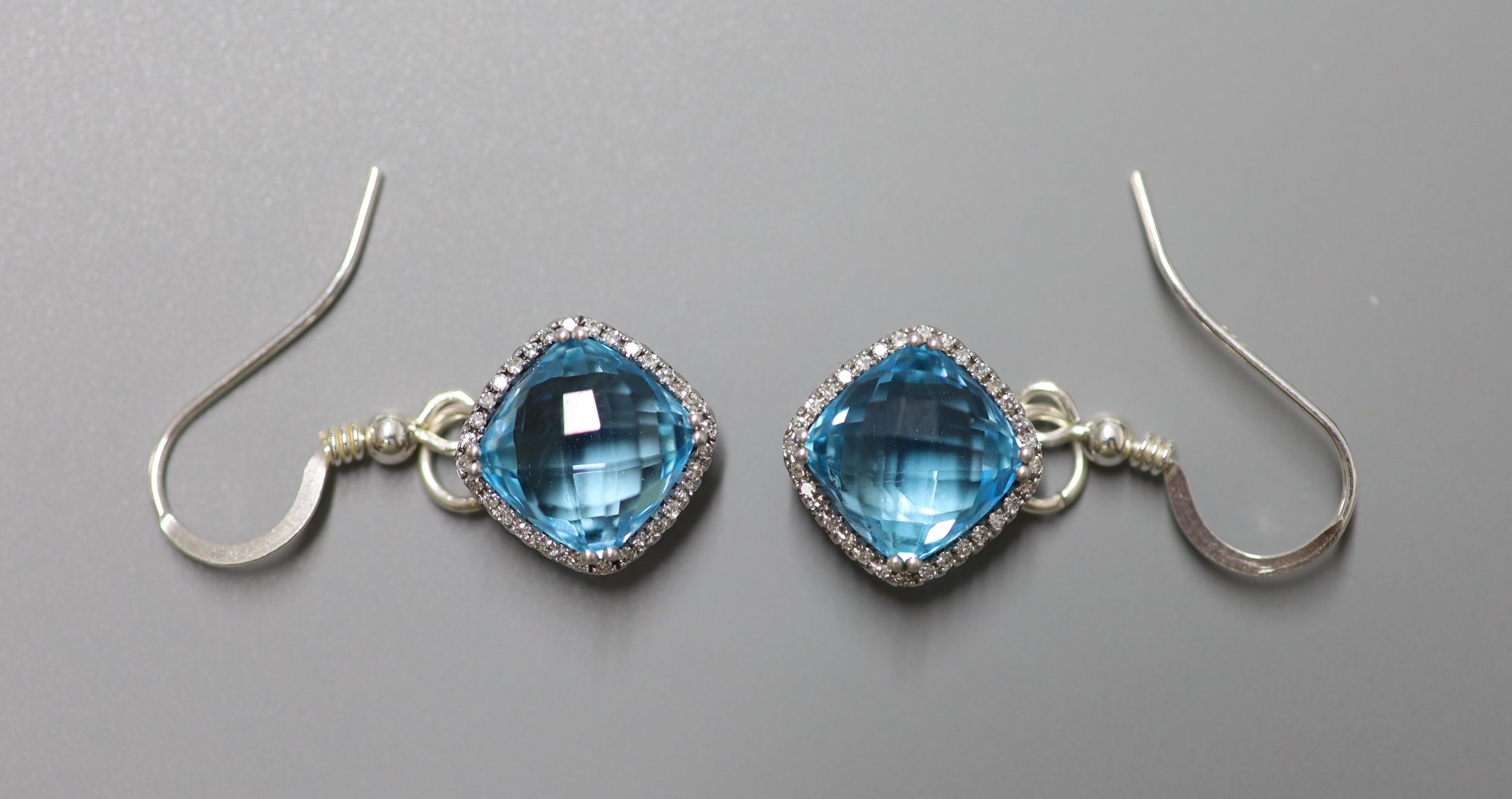 A modern 18ct white gold, blue topaz and diamond chip set dress ring, size L/M, gross 5 grams and a similar pair of drop earrings, stamped 375, gross 5 grams.